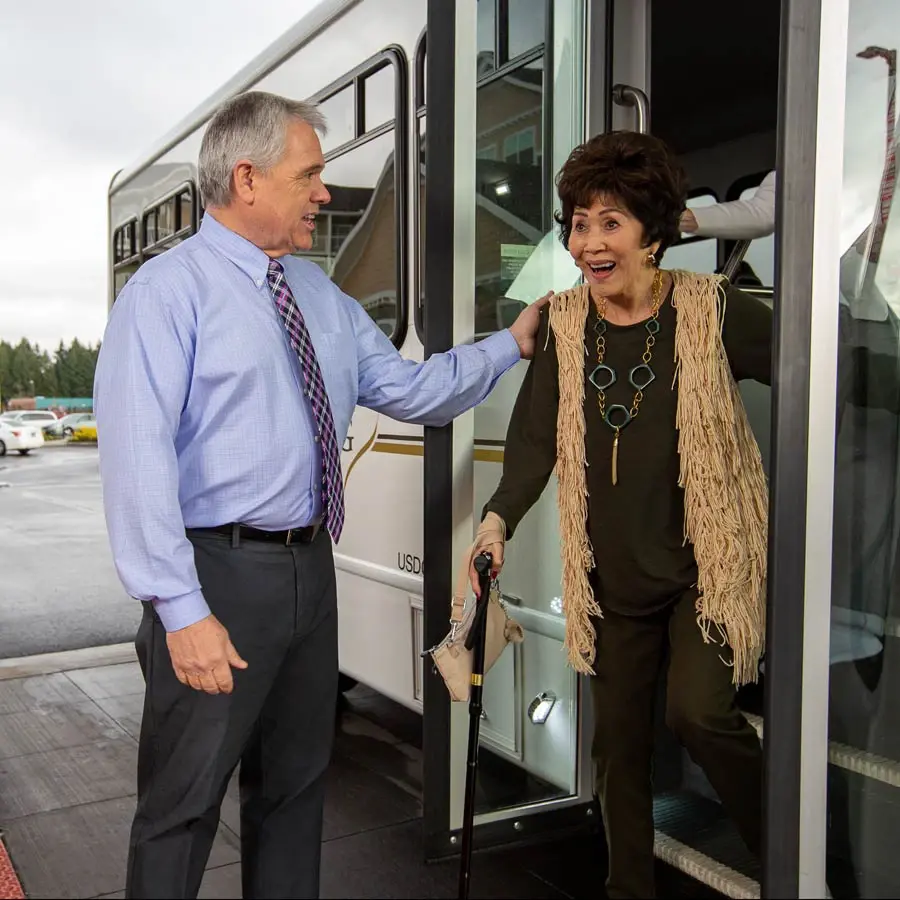 Sanford Estates man helping lady off bus